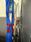 Two pairs of skis and poles and a fishing rod