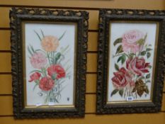 A pair of early twentieth century painted porcelain panels of roses and flowers, in scroll-work