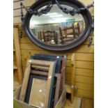 An ornately decorated oval bevelled glass wall mirror together with a parcel of various picture