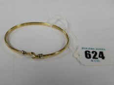 A 9ct yellow gold bangle with solitatire CZ