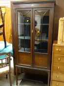 An Edwardian mahogany & decorated two-door display cabinet on raised feet with lower shelf
