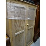 A vintage stripped pine two-door school-room shelved cupboard, 185 x 123 x 43cms