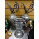 Two highly decorated pewter urns together with a twin-handled goblet