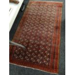 A mainly red ground Middle Eastern multi-squared pattern with narrow border, 176 x 97cms