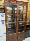 An Oriental hardwood glazed display & mirror backed cabinet with asymmetrical shelving, 196 x 102