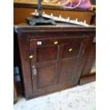 An antique oak hanging corner cupboard with brass fittings