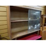 A vintage lightwood sliding door bookcase