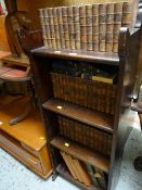 A vintage narrow bookcase containing a collection of bound novels