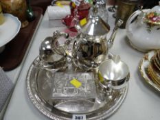 A modern silver coloured metal three-piece teaset on circular tray together with a continental