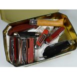 Tin containing a quantity of pen knives & Swiss army knives