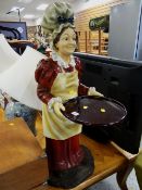 A resin figure of a female holding a tray