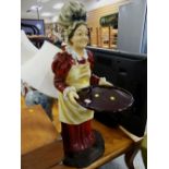 A resin figure of a female holding a tray