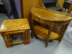 A Ducal honey pine demi-lune hall table with drawer together with a pine nest of three tables