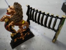 A modern painted cast rampant lion doorstop together with a brass fire grate front