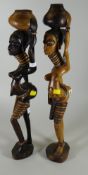 Two wooden carved African figures of females carrying water pots on their heads