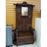 An early twentieth century oak mirror hall stand with lifting seat & carved lion arm decoration, 210