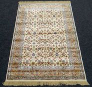 AN IVORY GROUND KASHMIR RUG all over design with unique gold boarder, 136 x 193cms