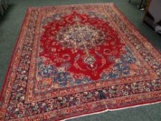 A LARGE PERSIAN MASHAD CARPET red ground traditional medallion design, 293 x 396cms
