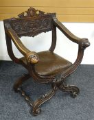 A CONTINENTAL CARVED X-SHAPED CHAIR with unusual mask-head terminals to the arms, studded