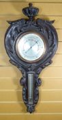 A CARVED OAK FRAME ANEROID BAROMETER with silvered two dials, 87cms