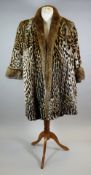A CIRCA 1940S OCELOT FUR SHORT-COAT with deep-turned brown fur cuffs and collar, brown silk lining