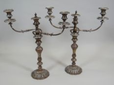 A PAIR OF SHEFFIELD PLATE THREE BRANCH CANDELABRA of ornate form, 53cms high