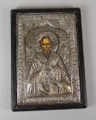 A BELIEVED SILVER RELIGIOUS ICON of St Nicholas, wooden mounted, 21 x 15cms