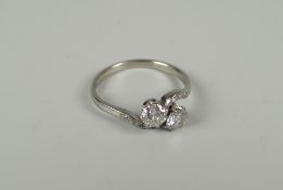 PLATINUM TWO-STONE DIAMOND CROSSOVER TWIST SHANK RING having diamond chips to the shoulders, the two
