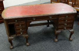 AN EDWARDIAN MAHOGANY DESK with red leather insert top, gadrooned border, carved ball and claw feet,