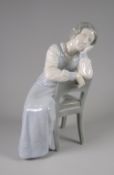 A B&G COPENHAGEN PORCELAIN FIGURE of a lady in long night-dress leaning on her hand, 23cms high