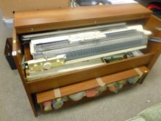 Brother knitting machine in cabinet with large quantity of wool reels and other associated items