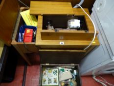 Singer sewing machine in wooden cabinet with pedal and a small wooden box of haberdashery items