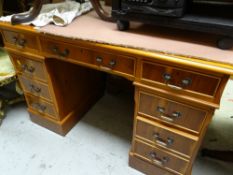 A reproduction yew kneehole desk with a red leather tooled top
