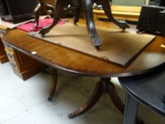 A reproduction mahogany twin-pedestal extending dining table
