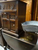 An oak drop leaf dining table together with an oak carved decorated cabinet