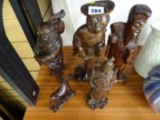 Four Oriental carved figures and a similar horse