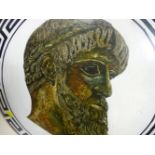 Ornamental metal warrior's shield with image of a Greek man