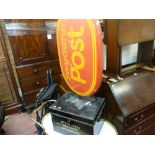 Black metal deed box with key and a red Post Office wall sign