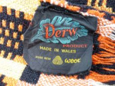 A VINTAGE WELSH WOOLLEN BLANKET with 'Derw' label in red, black and yellow traditional pattern tones