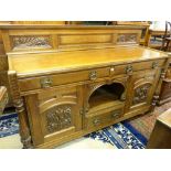A GOOD CARVED OAK RAILBACK SIDEBOARD with dog kennel centre and stylized brasswork, 123 cms high