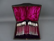 A TWELVE TEASPOON & SUGAR TONG SET, unmarked white metal in a satin lined fitted case, RD no.