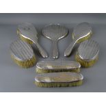 A FIVE PIECE SILVER DRESSING TABLE HAND MIRROR & BRUSH SET, Birmingham 1918 and two similarly styled