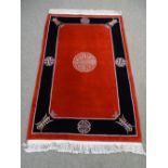 Oriental woolen red and black carpet with medalion designs and tassle ends 200 x 120cms