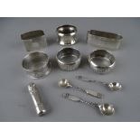 SIX VARIOUS SILVER NAPKIN RINGS, an amber type cheroot holder in silver container and three