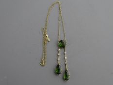 A BELIEVED SILVER FINE LINK NECK CHAIN with three pendant peridots, one circular cut and two pear