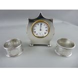 A NEAT ALL SILVER BEDROOM CLOCK, Chester, date mark rubbed, along with 2 silver napkin rings