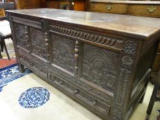 A HEAVILY CARVED LATE 17th/EARLY 18th CENTURY OAK DOWER CHEST, the top half hinged to give partial