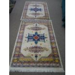 A pair of silk style rugs with aztec type design 185 x 135cms