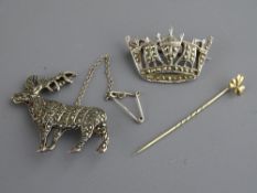 A MARCASITE STAG BROOCH marked 'Sil', a marcasite crown brooch and a nine carat gold clover leaf