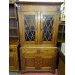 AN ANTIQUE WELSH OAK TWO PIECE CUPBOARD with upper glazed doors, twin frieze drawers and lower